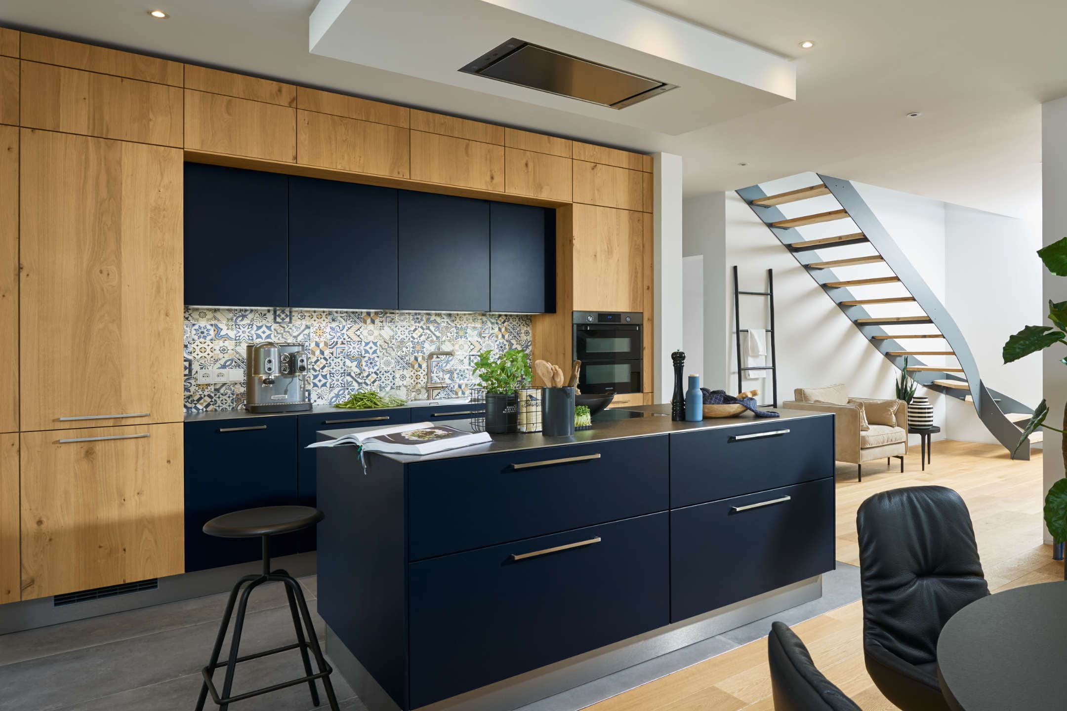Moderner Küchenraum mit blauer Kücheninsel und Holzschränken, stilvolles Design im Haus der Küchen im Eichsfeld. Offene Raumgestaltung mit Stilelementen und hochwertigen Oberflächen für Traumküchen.