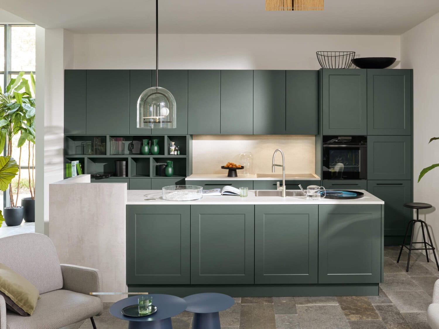 Hochwertige moderne Küche mit grünen Schränken, offen gestalteter Kücheninsel aus Marmor, stilvollen Dekorationen, viel natürlichem Licht und gemütlicher Wohnatmosphäre.